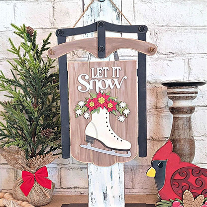 The "Let It Snow" sled sign from Janet's Craft Corner features a beautifully decorated white ice skate with flowers, resembling a sled. Accompanied by a small burlap-wrapped evergreen tree and a cardinal ornament, it's an ideal choice for holiday decor enthusiasts or crafting supplies lovers looking for a delightful DIY kit. Display it against a white brick wall for the perfect festive touch.