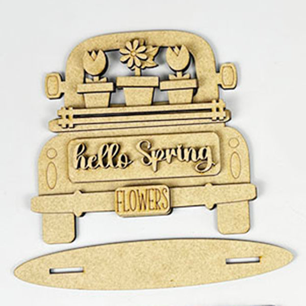 The Flower Market Mini Shelf Sitters from Janet's Craft Corner include a charming wooden cutout of a vintage truck carrying flower pots, adorned with a "hello Spring" message and a "FLOWERS" license plate. Ideal for craft lovers, this kit includes pieces that are ready to be assembled and hand-painted.