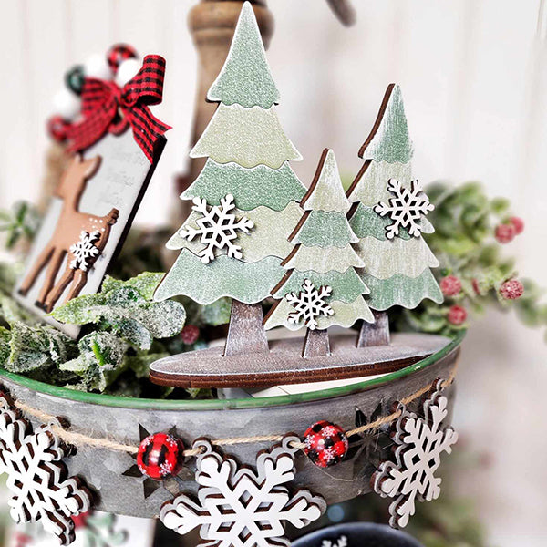 Janet's Craft Corner presents the Mistletoe Tiered Tray DIY Decor Kit, a 5-piece set featuring wooden Christmas trees embellished with white snowflakes. The kit includes a reindeer figurine and a plaid bow, bringing together charming holiday decor with mistletoe accents and an array of snowflake ornaments for a beautifully integrated two-tiered display.