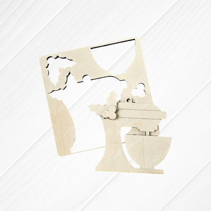 The Baking Spirits Bright Ornaments - Set of 4 DIY Decoration Kits by Janet's Craft Corner includes a wooden cutout of a stand mixer embellished with hand-painted holly leaves and berries. Ideal for holiday decor, it showcases negative space designs, such as a mixing bowl, all stylishly presented on an appealing wooden surface.