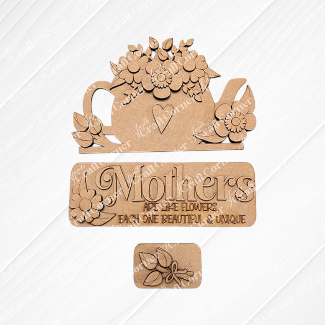 The "Mothers Interchangeable Insert" DIY home decor kit by Janet's Craft Corner includes a wooden teapot cutout adorned with flowers and a heart, along with a sign that says, "Mothers are like flowers, each one beautiful & unique." This delightful craft kit features interchangeable inserts and showcases a small flower bouquet design set against an embossed burlap-textured background.