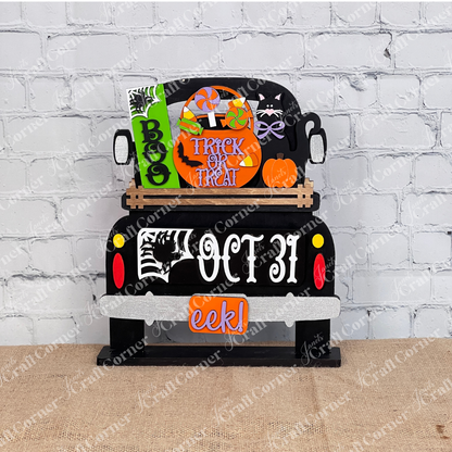 An enchanting Halloween-themed display depicts the rear of a truck adorned with vibrant signs that say "Boo," "Trick or Treat," and "Oct 31." This DIY craft kit from Janet's Craft Corner, named the Oct 31 Interchangeable Insert, features hand-painted elements including candies, a black cat with a pumpkin, and other festive decorations—ideal for creating versatile home decor.