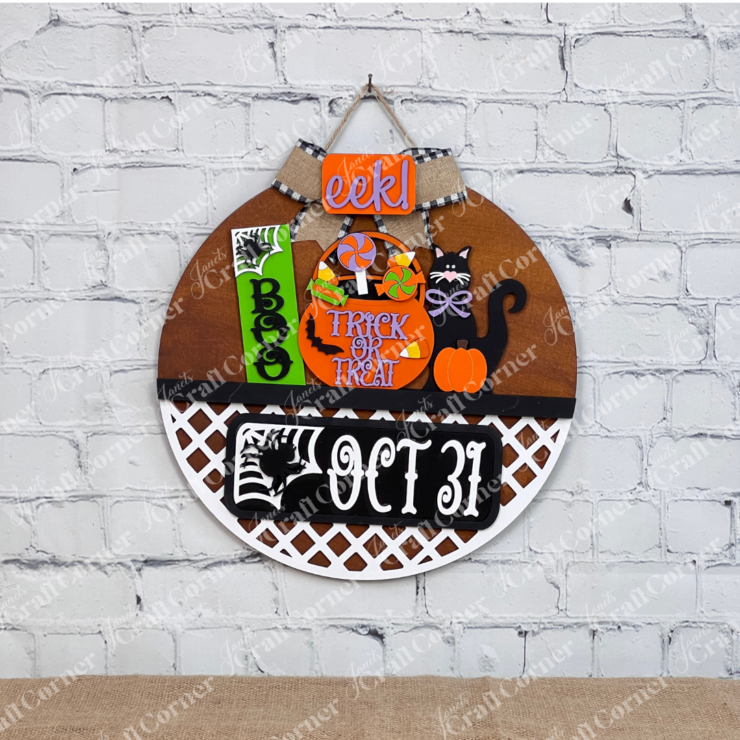 An enchanting Halloween-themed display depicts a stained door hanger with lattice bottom and signs that say "Boo," "Trick or Treat," and "Oct 31." This DIY craft kit from Janet's Craft Corner, named the Oct 31 Interchangeable Insert, features hand-painted elements including candies, a black cat with a pumpkin, and other festive decorations—ideal for creating versatile home decor.