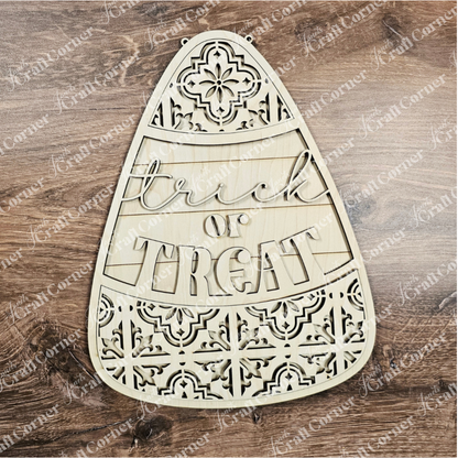 Wooden candy corn-shaped decoration with 'Trick or Treat' text on a wooden background