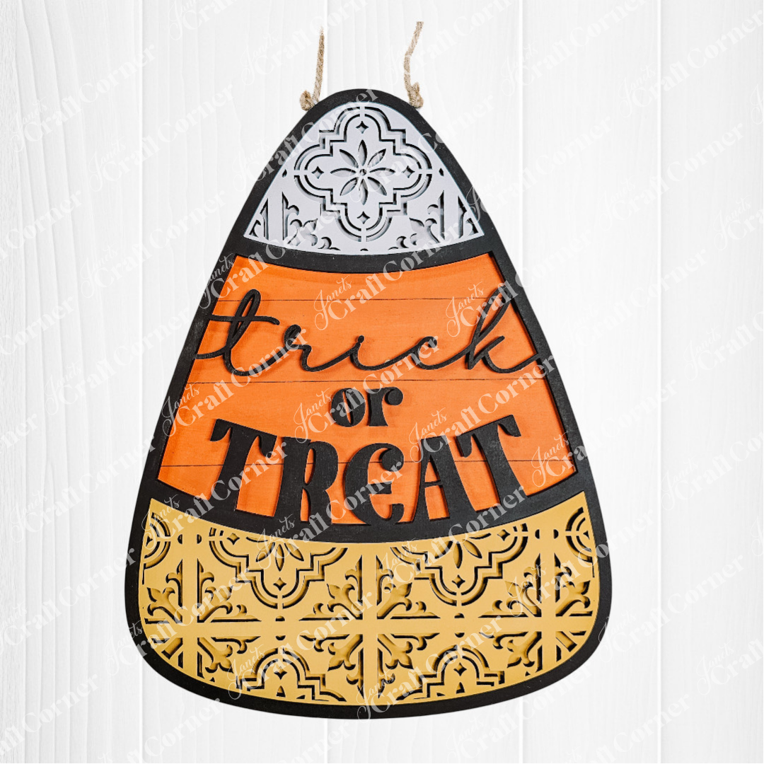 Halloween-themed candy corn decoration with 'Trick or Treat' text on a white background