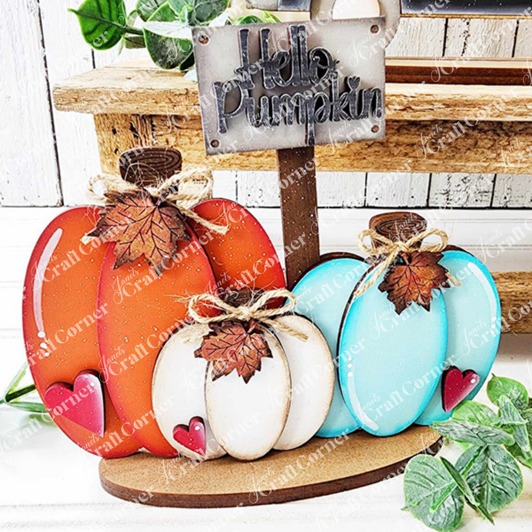 The Fall Harvest Mini Shelf Sitters from Janet's Craft Corner, available in 9 styles, make charming autumn decor—each DIY wooden pumpkin features a bow, metal leaf, and red heart to brighten your home.