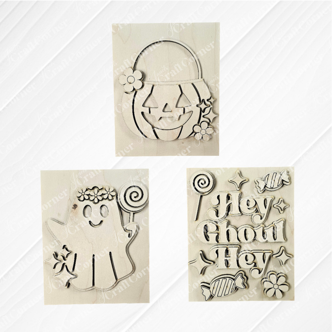 Janet's Craft Corner Halloween Farmhouse Signs: set of 3 wooden cutouts—a floral jack-o'-lantern, ghost with lollipop and flowers, and "Hey Ghoul Hey" tiered tray sign with candy—perfect for DIY seasonal home decor.