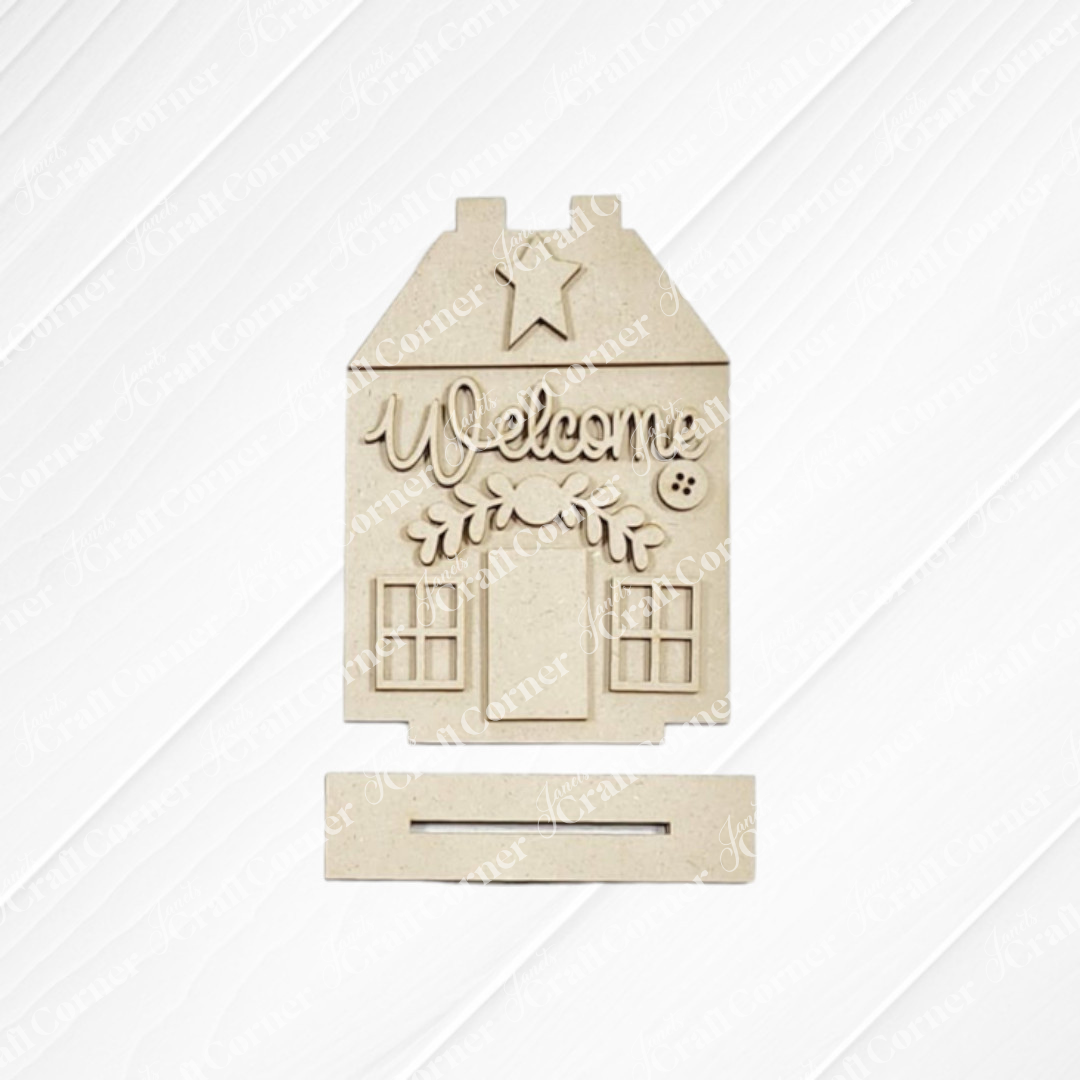 Janet's Craft Corner Heirloom Decor Set is a DIY seasonal home decor kit shaped like a house with "Welcome," decorative branches, star, and window details. The rectangular base has a slot, making it perfect for any space. Choose from 5 unique designs.