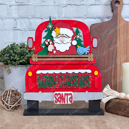 The Santa Merry Christmas Interchangeable Insert from Janet's Craft Corner is a DIY seasonal home décor kit of 3 pieces, featuring a red truck with Santa, trees, candy canes & “Merry Christmas” for festive table or rustic holiday accents.