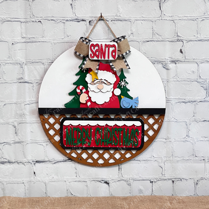 The Santa Merry Christmas Interchangeable Insert by Janet's Craft Corner is a DIY décor kit featuring a round sign with cartoon Santa, tree, blue bird, bow, and festive "Santa" and "Merry Christmas" text—perfect for holiday home decorating.