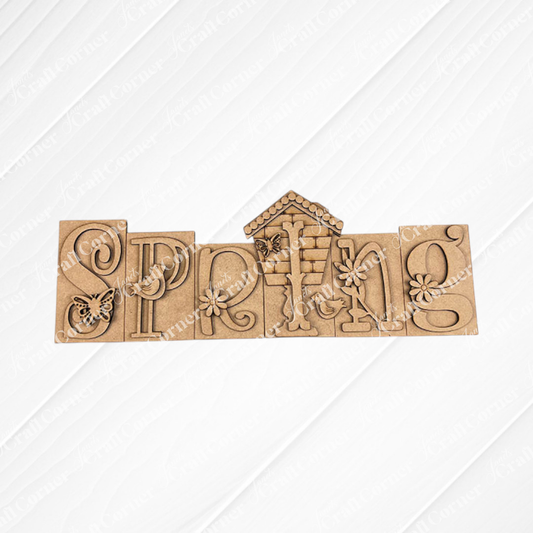 The "Spring Word Block Shelf Sitter" from Janet's Craft Corner is a DIY seasonal home decor kit featuring wooden blocks with floral and nature motifs, including butterflies and birds. Ideal for home decor, these blocks look stunning on textured white tiles atop a burlap surface.
