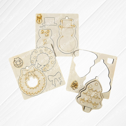 The Sugar Cookie Ornaments - Set of 3 DIY Decoration Kits from Janet's Craft Corner include festive cutouts: snowman, wreath with bow, and tree. Each piece is designed to fit perfectly into its outlined board, making them ready for you to decorate. Bring a personalized charm to your home décor with this delightful craft set.