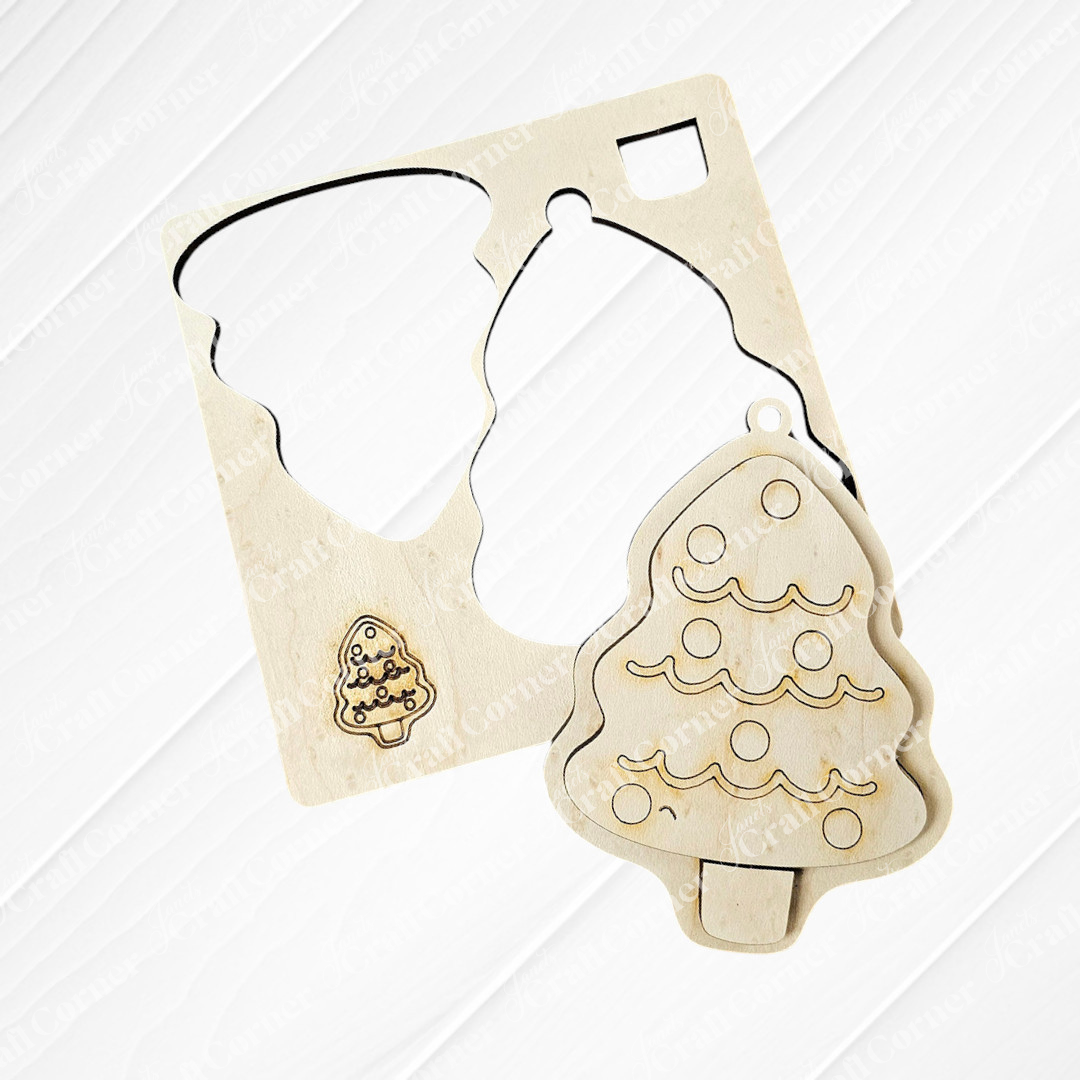 A wooden Christmas tree ornament, reminiscent of Janet's Craft Corner's Sugar Cookie Ornaments DIY Decoration Kit, sits next to its matching cut-out within a wooden stencil. The ornament showcases circular decorations and wavy lines, similar to sugar cookie designs, while the stencil rests on a wooden surface.