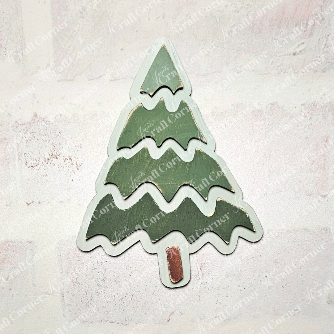 A wooden Christmas tree ornament from Janet's Craft Corner's Trim a Tree Kids Pop-Out Kit rests on a light textured background. The tree, perfect for personalizing holiday décor, features three green tiers with a small brown trunk at the bottom.