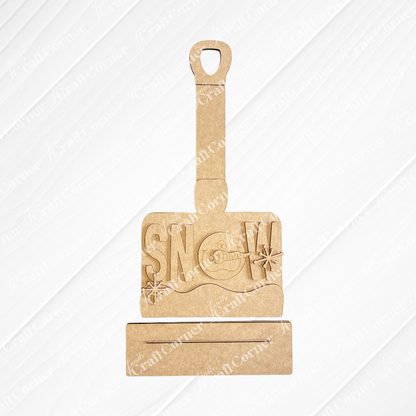 The Winter Snow Shovel Shelf Sitter DIY kit by Janet's Craft Corner features a gray shovel with “SNOW” cutouts and a snowman in the “O”—a charming winter décor piece for your home. Set of 1.