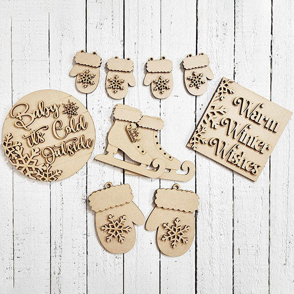 Transform your space into a winter wonderland with Janet's Craft Corner's Winter Wonderland Decor Set. This DIY home decor kit includes intricately carved ice skates, mittens, snowflakes, and signs with "Baby it's Cold Outside" and "Warm Winter Wishes," perfect for a white wooden tiered tray display.