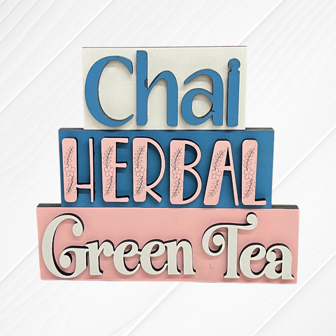 Janet's Craft Corner Word Stacks - Painted: three wooden signs with "Chai" (white), "Herbal" (blue), and "Green Tea" (pink) in decorative fonts, stacked against a white background.