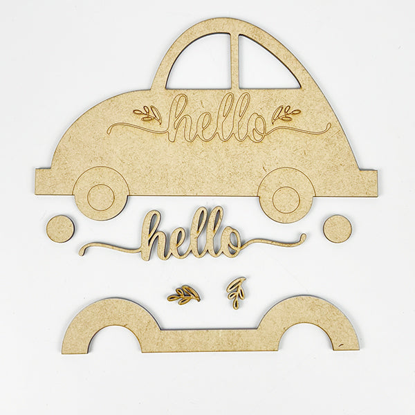 On a white background, you'll find wooden craft pieces shaped like a Volkswagen, the word "hello," and decorative leaves. This DIY kit, named Hello Volkswagen by Janet's Craft Corner, features a car shape divided into parts for easy assembly, making it an ideal choice for charming farmhouse decor or as a shelf sitter.