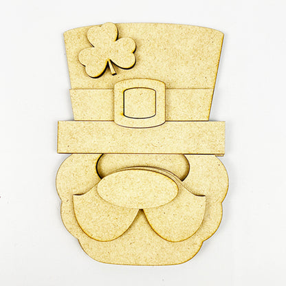 Introducing the "Lucky St. Patrick's Tiered Tray Kit" by Janet's Craft Corner, which includes a whimsical leprechaun face cutout perfect for your seasonal décor. This charming piece, made from beige material, features a large top hat with a four-leaf clover and showcases simple geometric shapes that form its prominent nose and bushy facial hair—an ideal addition to your festive crafting projects.