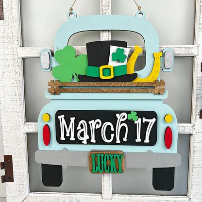 The "March 17 Interchangeable Insert" from Janet's Craft Corner is a decorative piece designed to resemble the back of a truck, perfect for celebrating St. Patrick's Day. It features symbols like a shamrock, leprechaun hat, and horseshoe, along with the date "March 17." With "LUCKY" displayed on the license plate, this DIY home decor kit makes an ideal piece of interchangeable home decor against a white, rustic background.