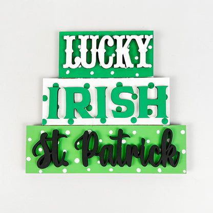 The Janet's Craft Corner Lucky St Patricks Tiered Tray Kit features three stacked rectangular signs with the words: "LUCKY" on green, "IRISH" on white with green polka dots, and "St Patrick" on light green with white polka dots. This delightful kit is perfect for festive decorating and brings charm to your home décor with its playful text styles.