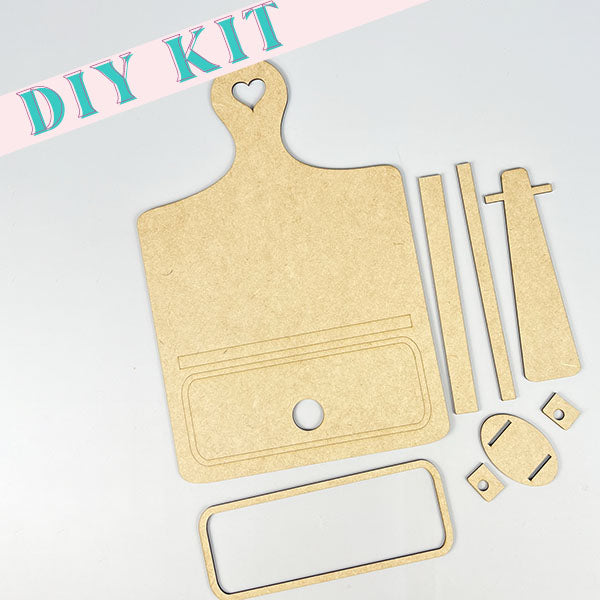 Presented with tidy precision, this DIY home decor kit by Janet's Craft Corner includes an interchangeable breadboard featuring wooden pieces such as a board with a heart-shaped handle, rectangular strips, and circular components. The phrase "DIY KIT" is prominently displayed in the top left corner. Ideal for crafting personalized projects or elevating your home decor with versatile accessories.